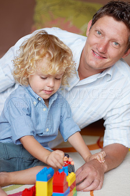 Buy stock photo Father relax with boy child, building blocks with toys for development and growth, playing together while at home. Family, man bonding with kid and learning, educational play time in portrait