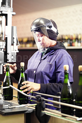 Buy stock photo Alcohol, bottle wine and woman working in a distillery or industrial factory. Equipment, glass bottles and female worker with ppe work on red champagne beverage production machine in warehouse