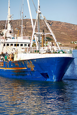 Buy stock photo Shot of a fishing trawler returning to harbour