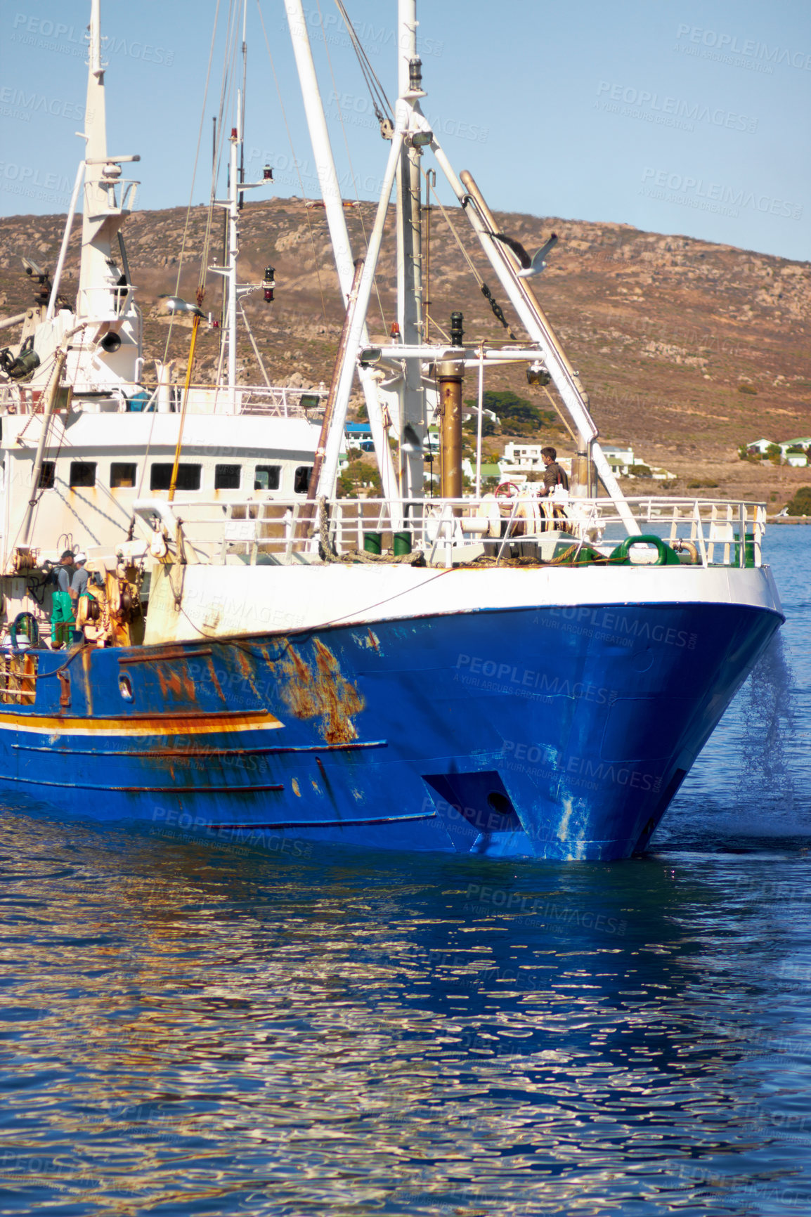 Buy stock photo Shot of a fishing trawler returning to harbour