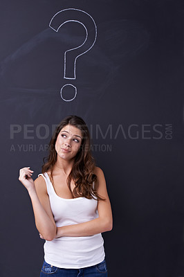 Buy stock photo Thoughtful young woman standing beneath a chalk drawing of a question mark