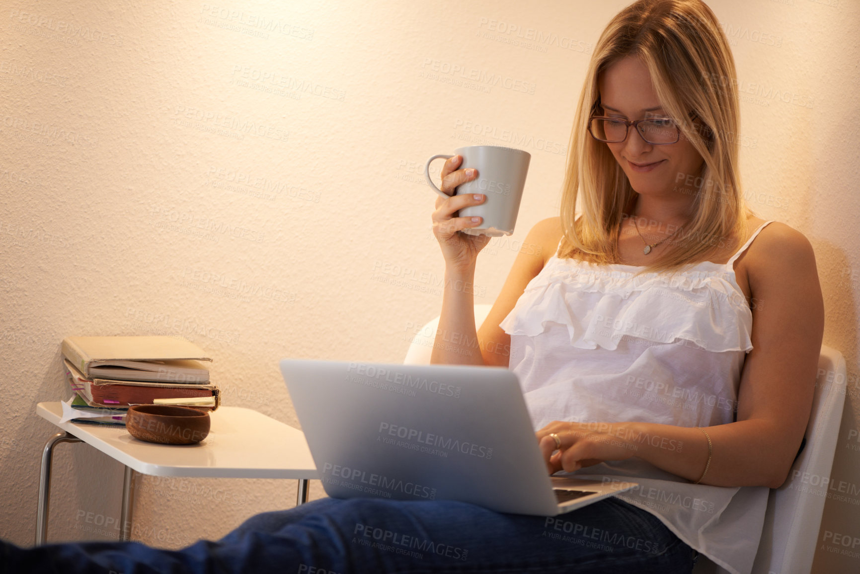 Buy stock photo Happy woman, laptop and journalist with coffee in relax on chair reading, typing or writing in living room at home. Female person or freelancer smile on computer with tea cup in remote work at house