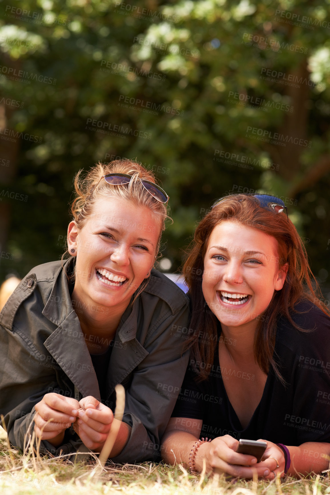 Buy stock photo Portrait of two young girls lying together the grass with copy space