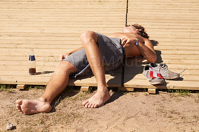Buy stock photo Outdoor, man and drunk with summer, tired and fatigue with heat stroke, concert and sunshine. Pass out, person and guy on a board, musical festival and outside with event, exhausted and topless