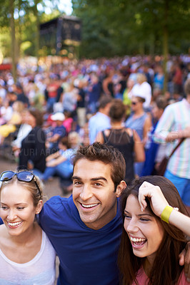 Buy stock photo A group of smiling friends enjoying a music festival with crowd in the background