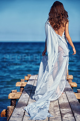 Buy stock photo Rear view of a young woman walking on a wharf