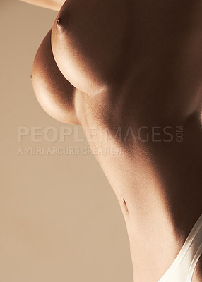 Buy stock photo Low angle studio shot of a woman posing topless