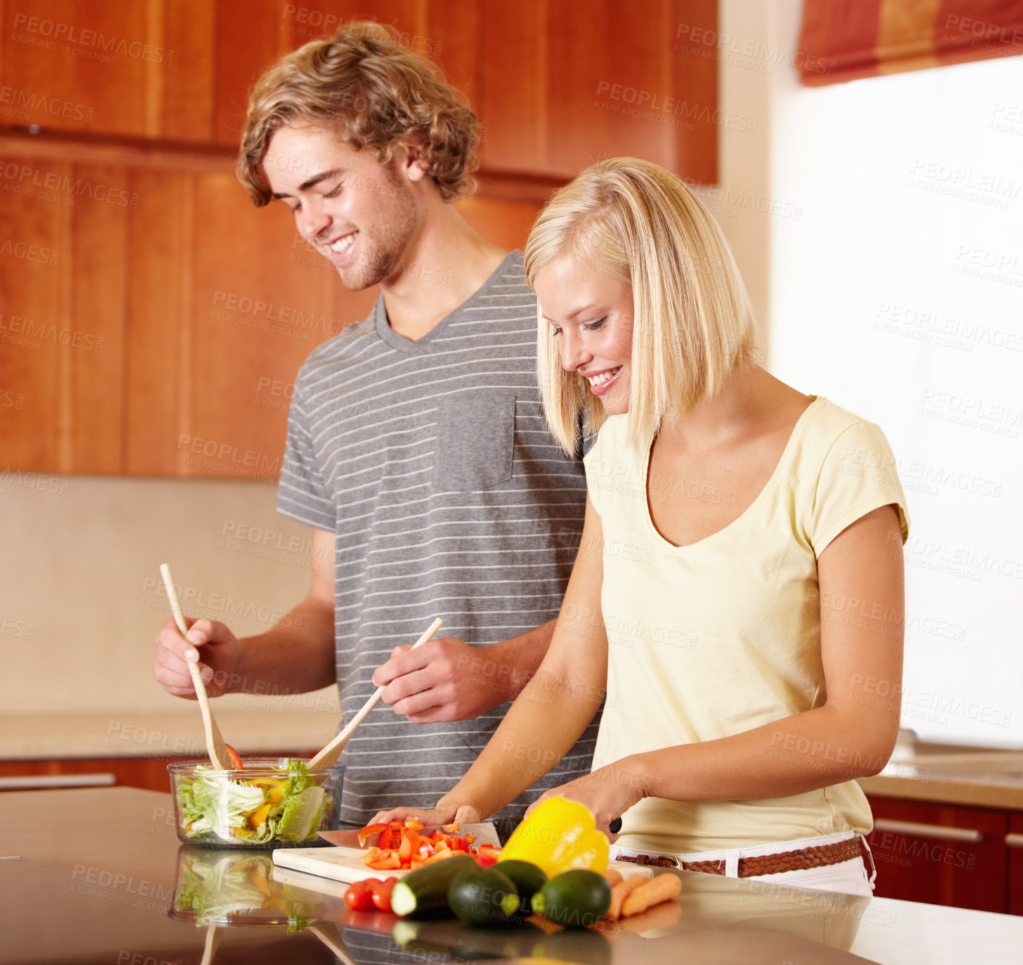 Buy stock photo A young couple making dinner in the kitchen