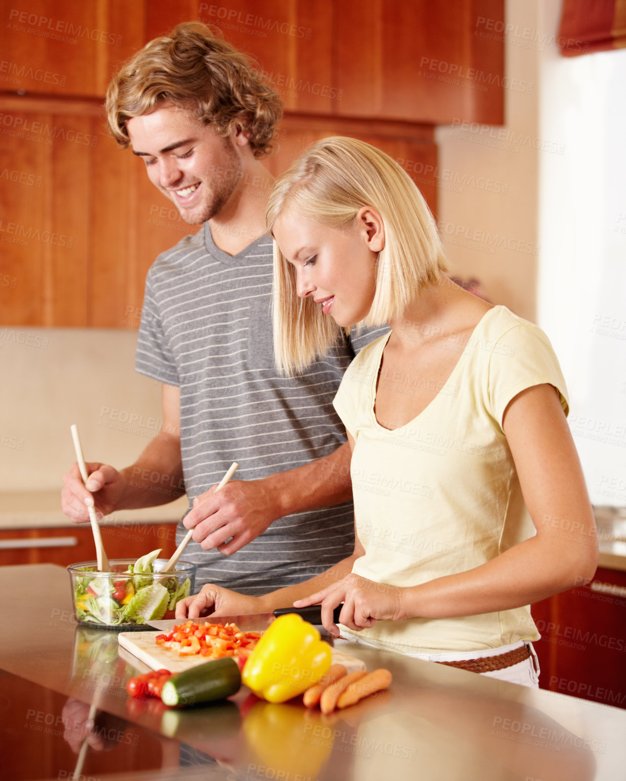 Buy stock photo A young couple preparing some food in the kitchen