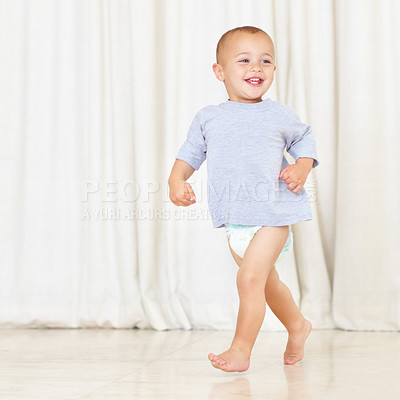 Buy stock photo Full length shot of a cute little boy walking around the house in a nappy and t-shirt