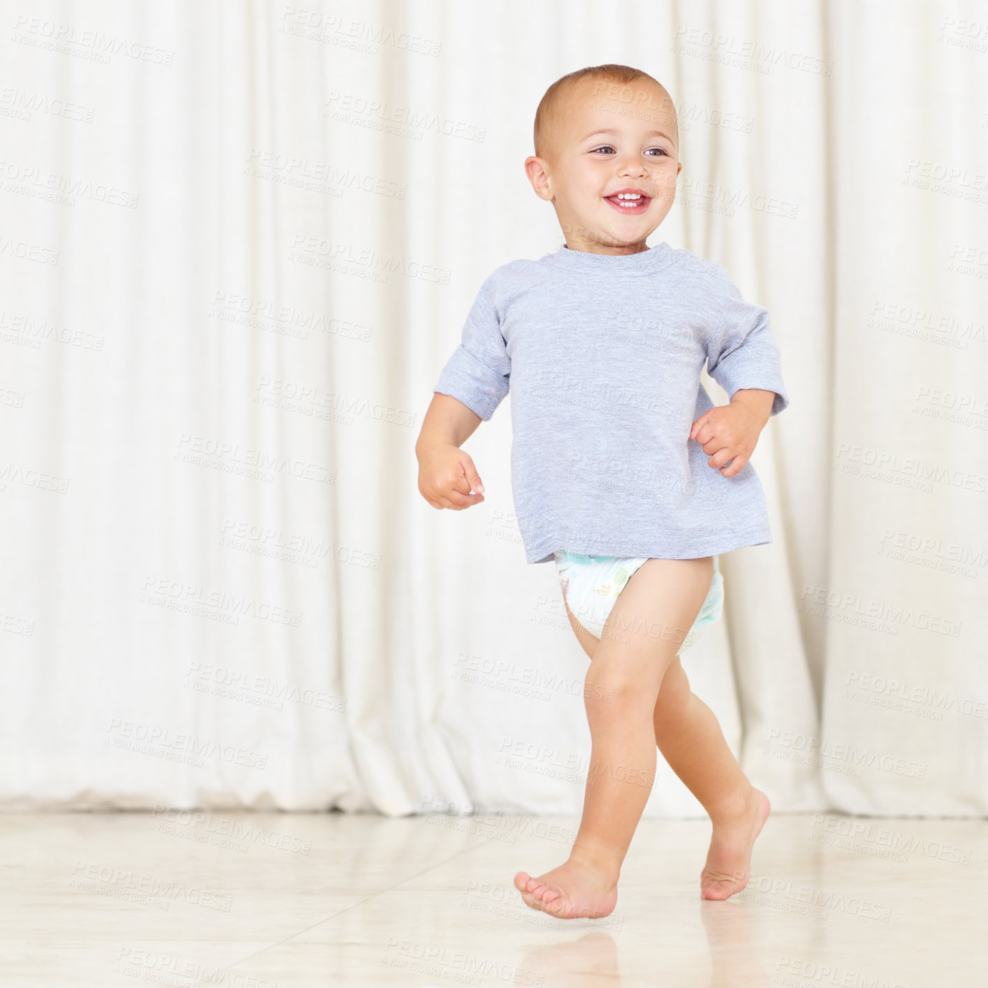 Buy stock photo Full length shot of a cute little boy walking around the house in a nappy and t-shirt