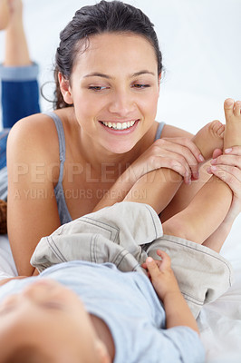 Buy stock photo Young woman, legs and playing with baby on bed in childcare, bonding or love together at home. Happy mother, little child or toddler smile lying in relax, playful feet or childhood in bedroom care