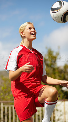 Buy stock photo Shot of a female soccer player kicking around a soccer ball