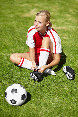 Buy stock photo Woman, soccer and tie shoelace on field, safety and start training for fitness, health or competition on pitch. Girl, shoes and football for preparation, ready and thinking for sport contest on grass