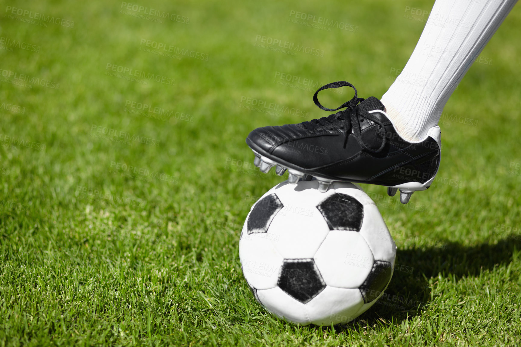 Buy stock photo Cropped shot of a female football players leg standing on a soccer ball