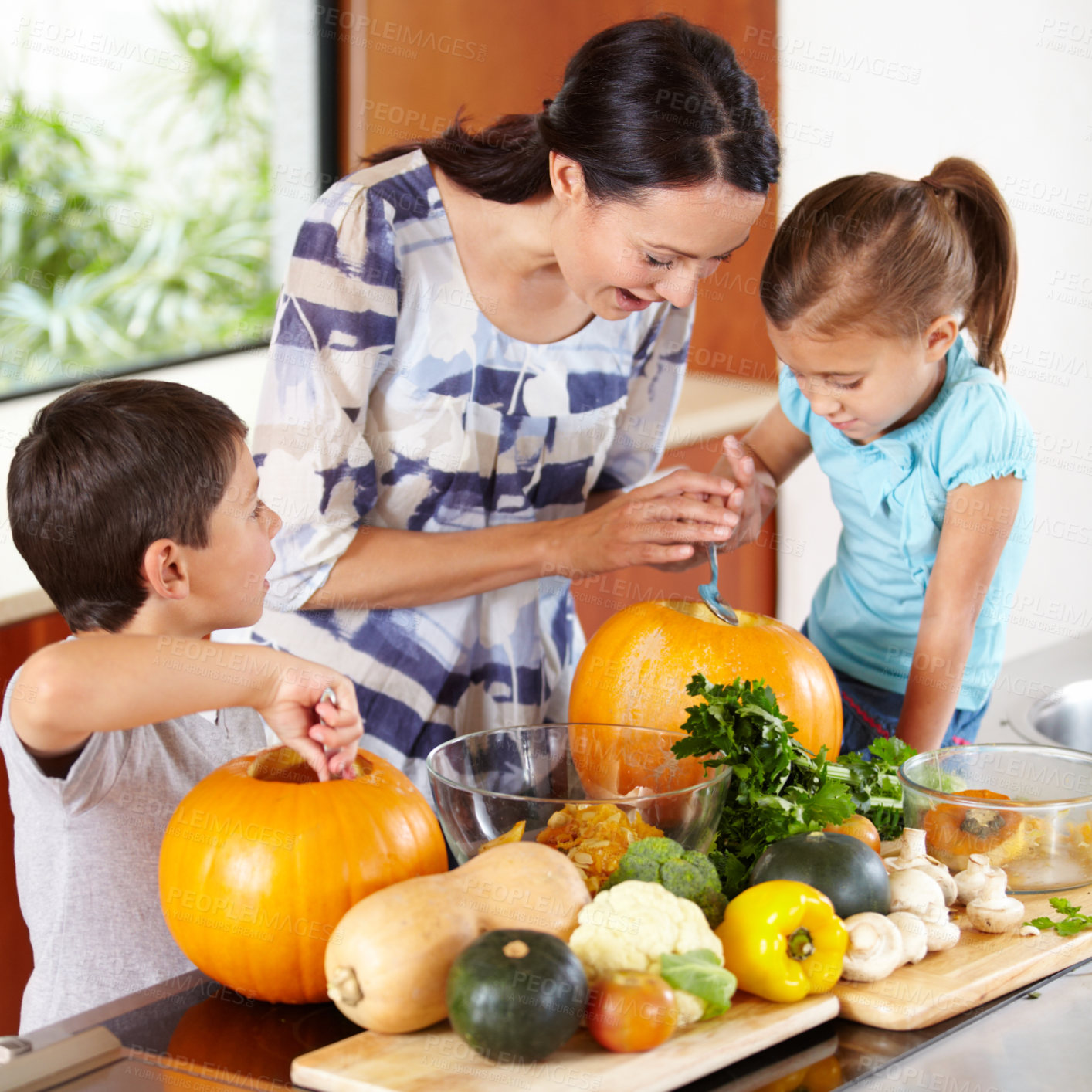 Buy stock photo Mom, daughter and son with pumpkins for halloween in the kitchen of their home for holiday celebration. Family, food or tradition and a woman teaching her kids how to carve vegetables in an apartment