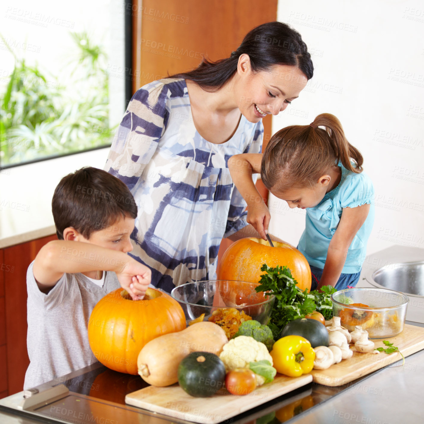 Buy stock photo Mother, daughter and son with pumpkins for halloween in the kitchen of their home for holiday celebration. Family, food or tradition and a woman teaching her children how to carve vegetables