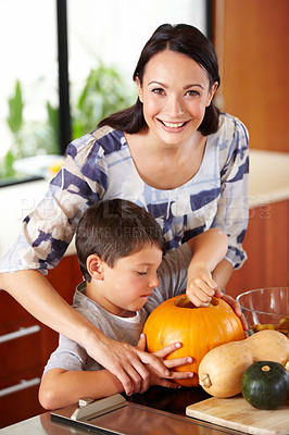 Buy stock photo Halloween, pumpkin and a woman in the kitchen with her son for holiday celebration at home. Creative, smile or happy with a mother and boy child carving a face into a vegetable for decoration