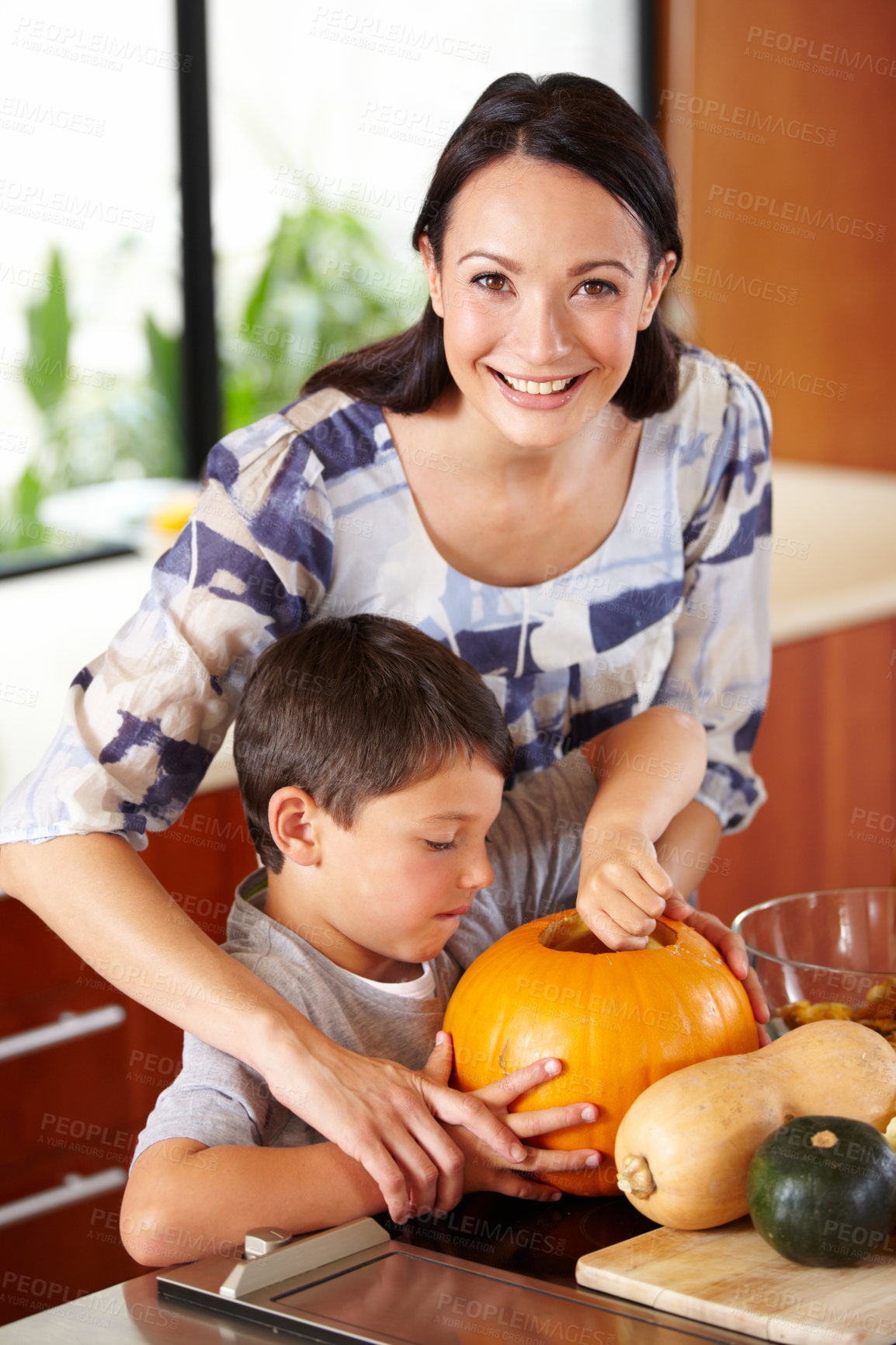Buy stock photo Halloween, pumpkin and a woman in the kitchen with her son for holiday celebration at home. Creative, smile or happy with a mother and boy child carving a face into a vegetable for decoration