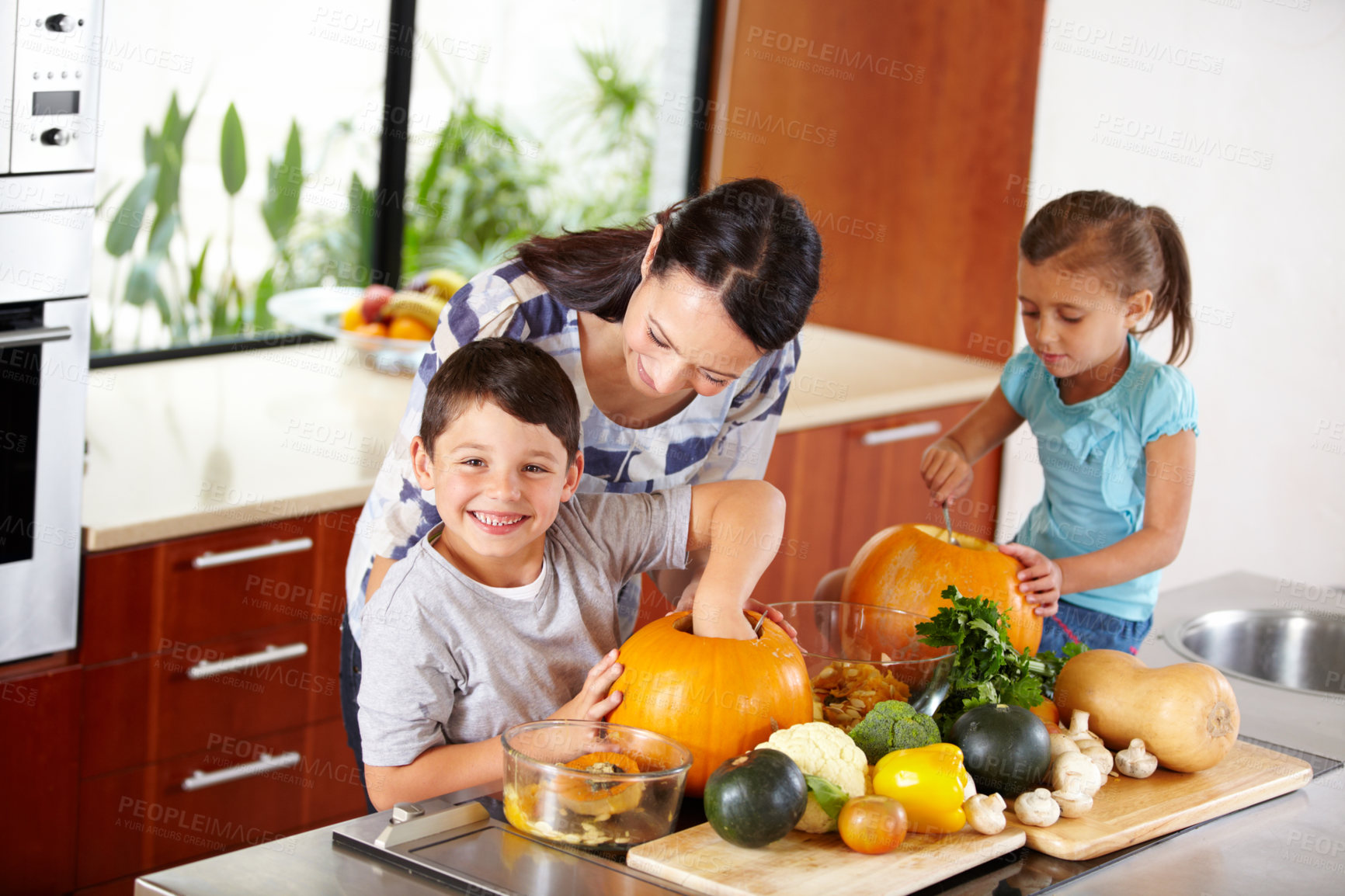 Buy stock photo Mother, sister and brother with pumpkins for halloween in the kitchen of their home for holiday celebration. Family, food or tradition and a woman teaching her sibling kids how to carve vegetables 