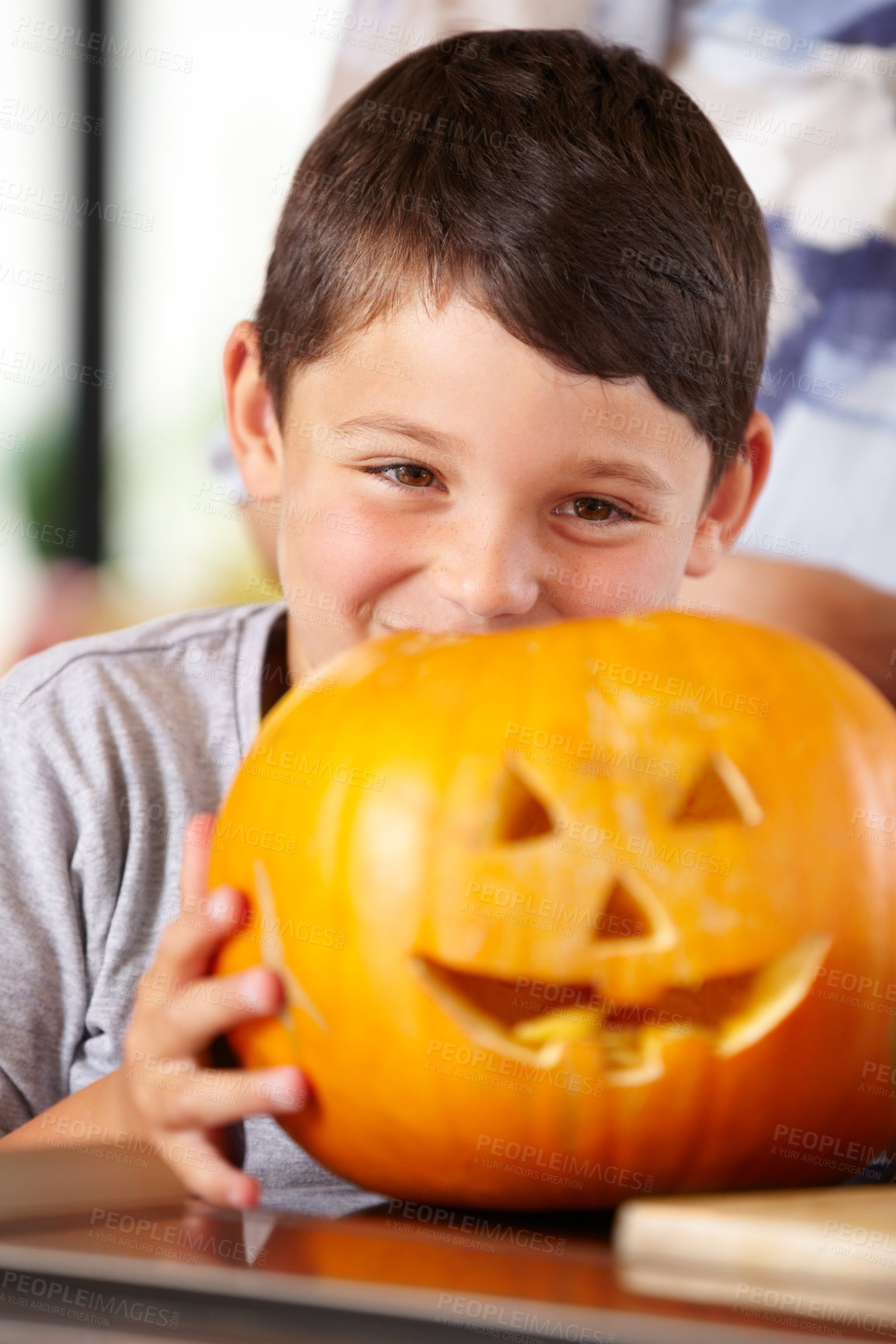 Buy stock photo Face, halloween, and pumpkin with a boy in the kitchen of his home for holiday celebration or tradition. Smile, scary and carving with a young child closeup in his apartment for vegetable decoration