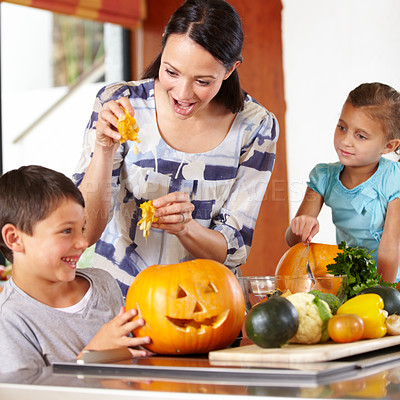 Buy stock photo Mother, girl and boy with pumpkins for halloween in the kitchen of their home for holiday celebration. Family, food or tradition and a woman teaching her young children how to carve vegetables