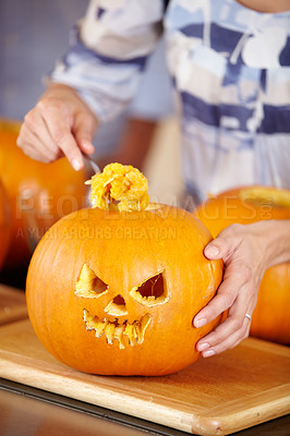 Buy stock photo Closeup of a woman hollowing-out a Jack O'lantern for Halloween