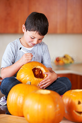 Buy stock photo Halloween, pumpkin and boy child in the kitchen for holiday celebration at modern home. Creative, smile and happy young kid bonding and carving vegetable for decoration or tradition at family house.