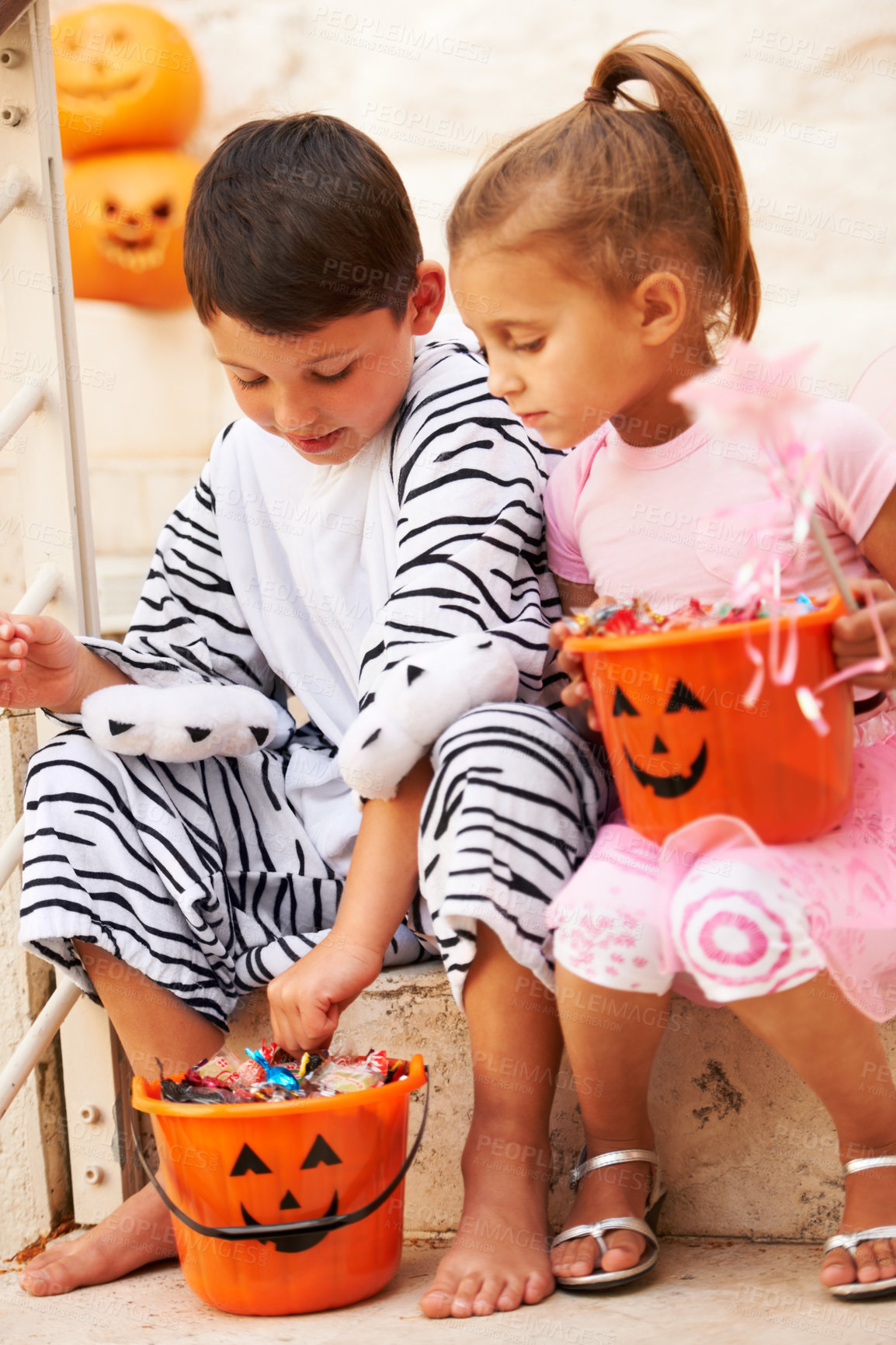 Buy stock photo Shot of two cute kids checking out their Halloween candy