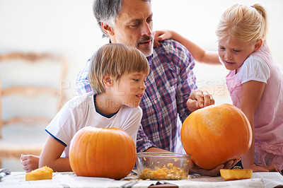 Buy stock photo Halloween, family and carving a pumpkin with children at a home table for fun and bonding. Man or dad helping or teaching young kids with creativity, holiday lantern and craft together in a house