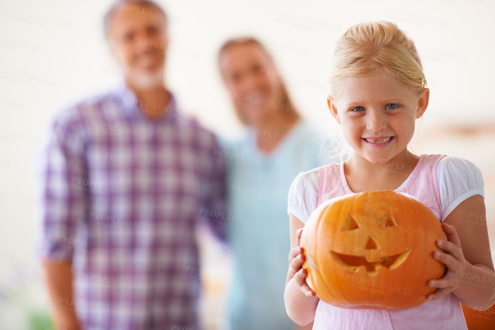 Buy stock photo Girl, pumpkin lantern and portrait with parents, portrait and smile for celebration, holiday and play. Child, mom and dad with vegetable for halloween, art and happy in family home with creativity