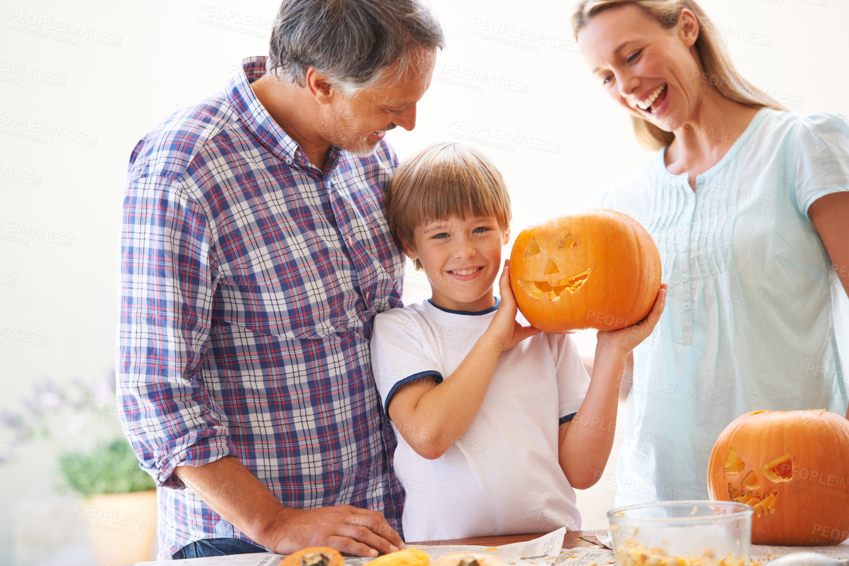 Buy stock photo Halloween, family and carving a pumpkin with a child in a home for fun and bonding. Man and woman or parents and young kid for portrait together for creativity, holiday lantern and happy craft