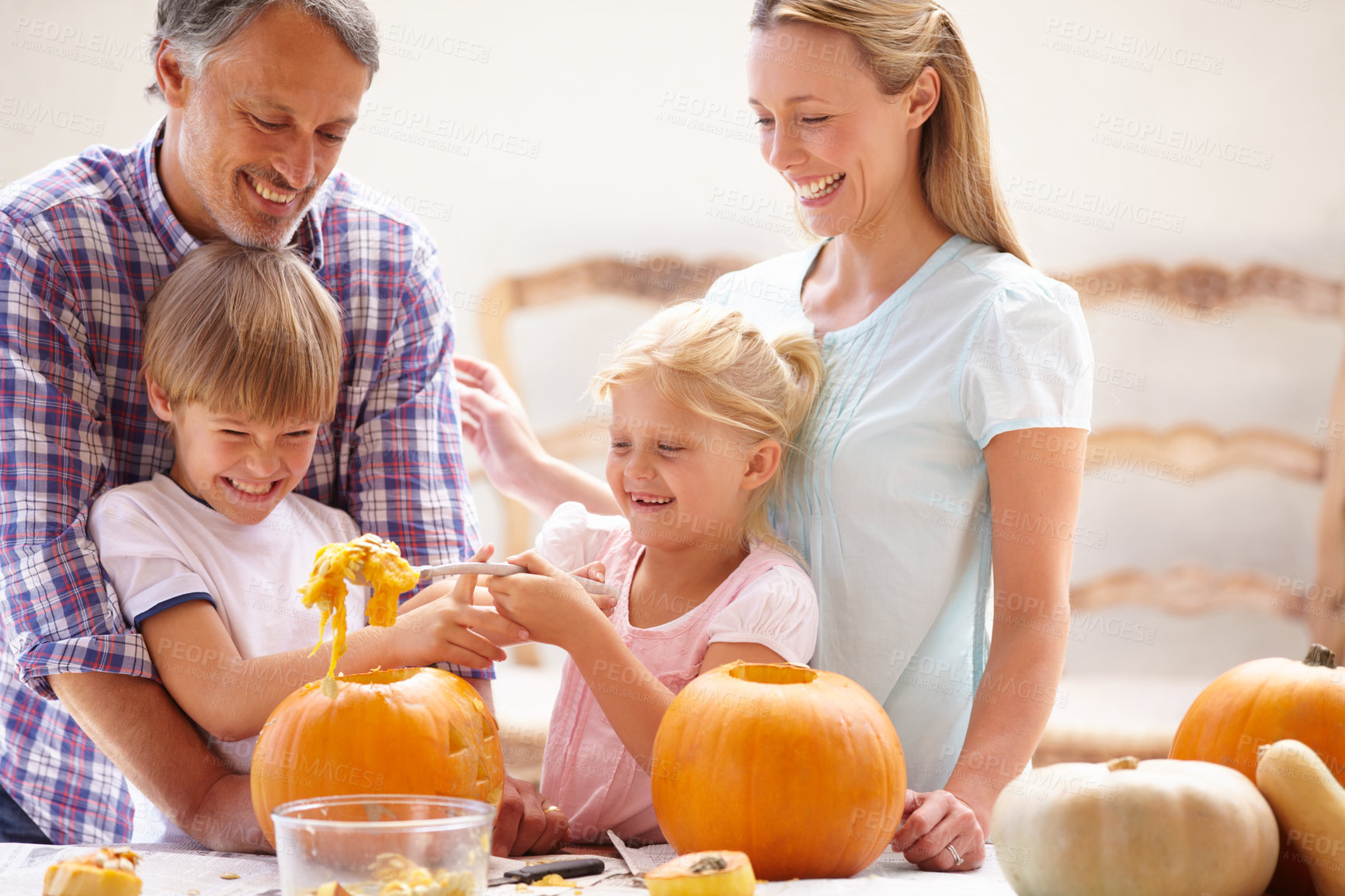 Buy stock photo Family, smiling and carving halloween pumpkins for holiday decoration, childhood memories and joyful. Parents, children and playful together with excitement, celebration and autumn tradition