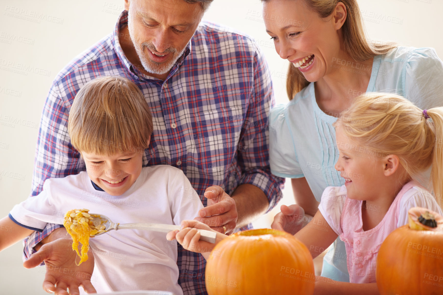 Buy stock photo Halloween, family fun and carving a pumpkin with children in a home for bonding and helping with craft. Man and woman or parents and young kids together for creativity, holiday lantern and happy
