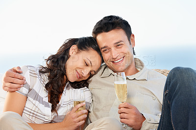 Buy stock photo A cute couple drinking champagne with the ocean in the background