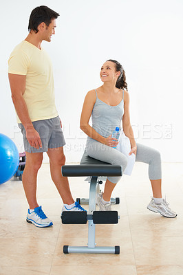 Buy stock photo Two young people talking to each other at the gym