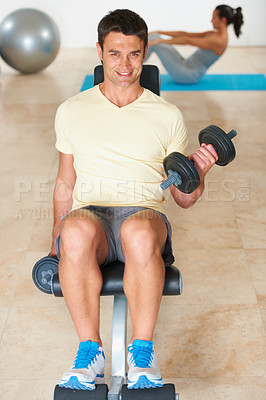 Buy stock photo A young man lifting weights