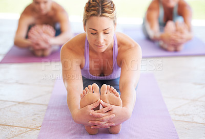 Buy stock photo Young yoga instructor leading a class