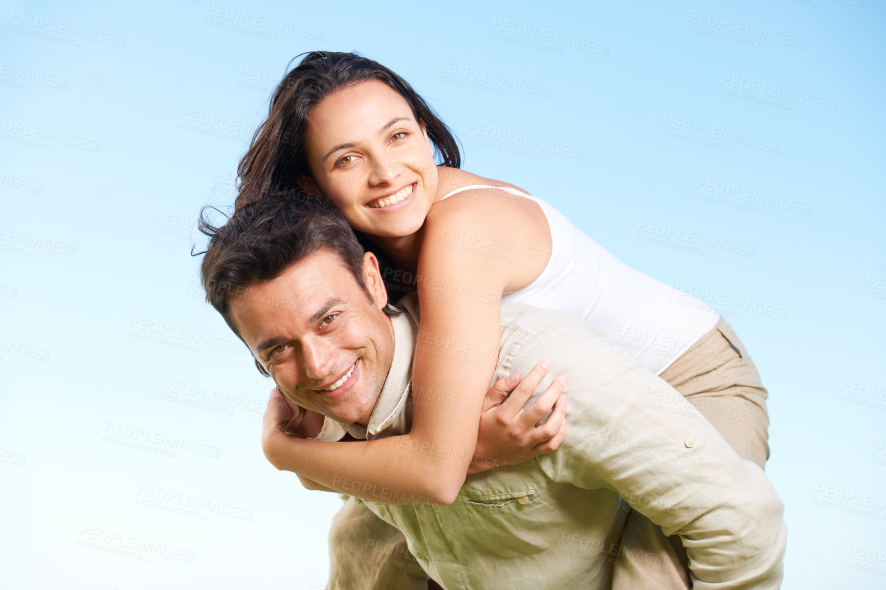 Buy stock photo A handsome young man  giving his girlfriend a piggyback outdoors