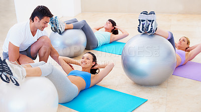 Buy stock photo Personal trainer, pilates and ball for helping women with balance, posture and happy for training, fitness and gym. Man, exercise and help woman in class with stretching, wellness or workout on floor