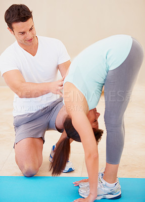 Buy stock photo Man, yoga and personal trainer with young woman stretching body for fitness, exercise or workout at gym. Male yogi instructor, coach or mentor assisting female in warm up stretch or pose on floor mat