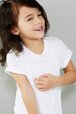 Buy stock photo A smiling little boy casually standing with his hand on his chest against a grey background