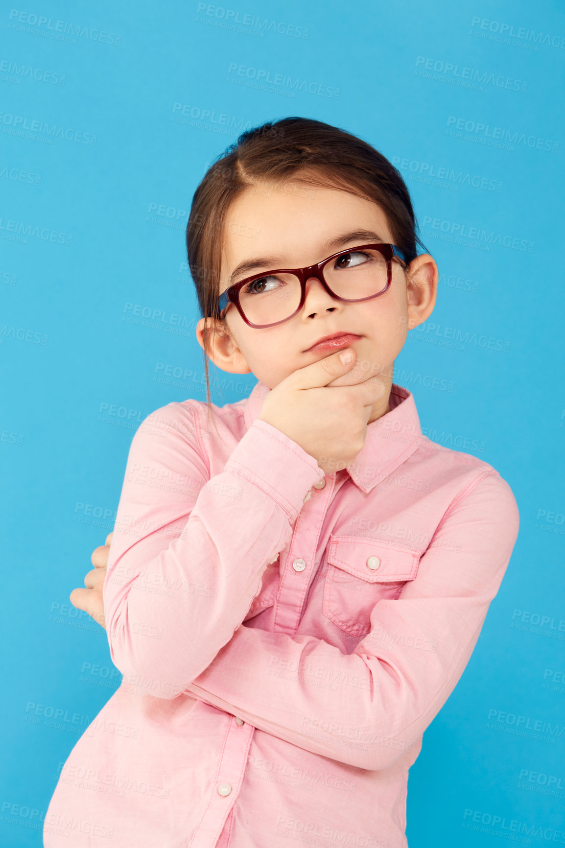 Buy stock photo Thinking, ideas and girl with decision, choice and happiness against a blue studio background. Female child, kid and young person with glasses, thoughts and wonder with information, future and geek