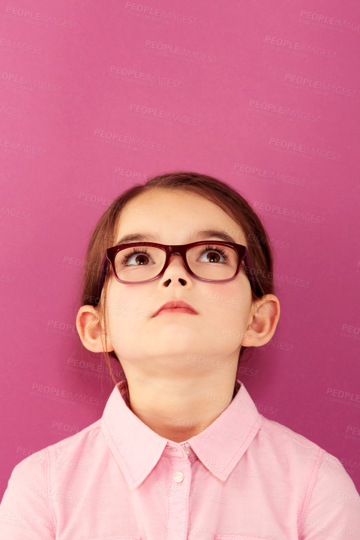Buy stock photo Glasses, child and looking up with thinking geek and modern fashion in a studio with serious face. Kid, eyewear and sight with outfit and nerd with accessory and pink background with confidence