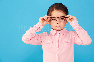 Buy stock photo Glasses, child and portrait with eye, geek and modern fashion in a studio with serious face. Kid, eyewear and sight with youth outfit and nerd with accessory and blue background with confidence