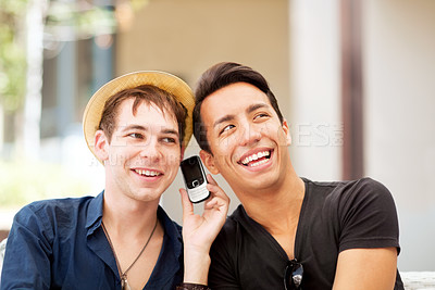 Buy stock photo Happy, phone call and friends listening to a message, communication or audio conversation. Thinking, smile and men with a mobile to listen to a person speaking on an app or funny joke in the city