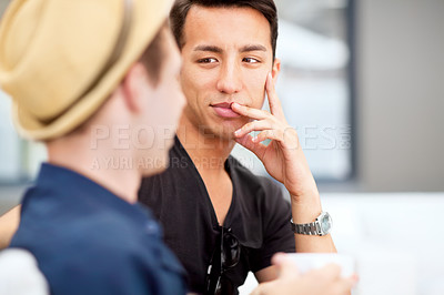 Buy stock photo Shot of a young man listening to his friend talk