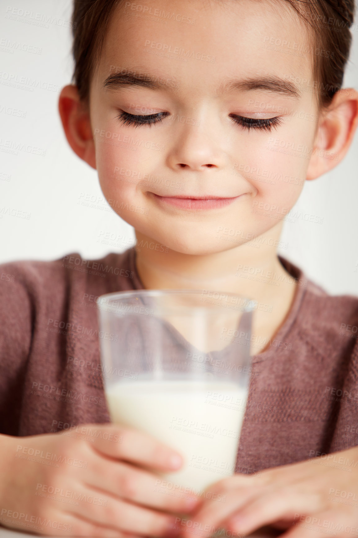 Buy stock photo Cropped shot of a cute little girl looking happily at a glass of milk