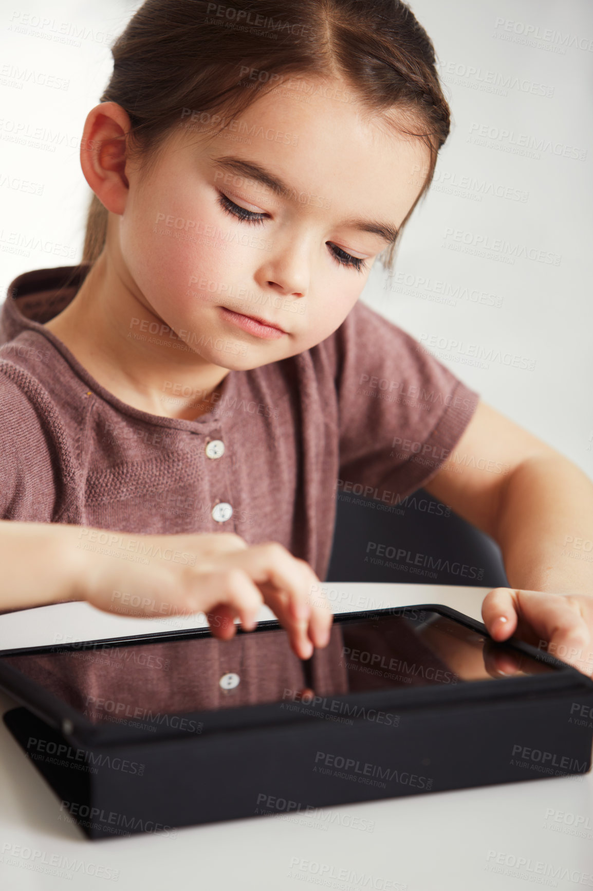Buy stock photo Little girl, tablet and watching in living room for online entertainment, games or research at home. Face of young female person, child or kid with technology for communication or networking at house