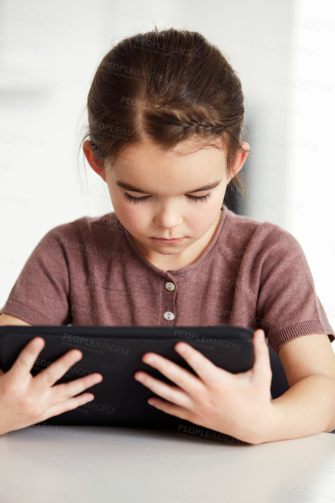 Buy stock photo Little girl, tablet and watching on table in living room for online entertainment, games or research at home. Female person, child or kid with technology for communication or networking at house